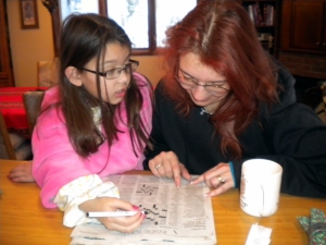 teaching Elena Grace (in her made-by-Grandy Christmas bathrobe) how to do crosswords