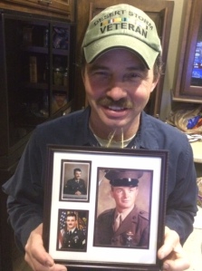 Jon (Desert Storm combat vet) holding Service photos of himself, his brother, and their dad