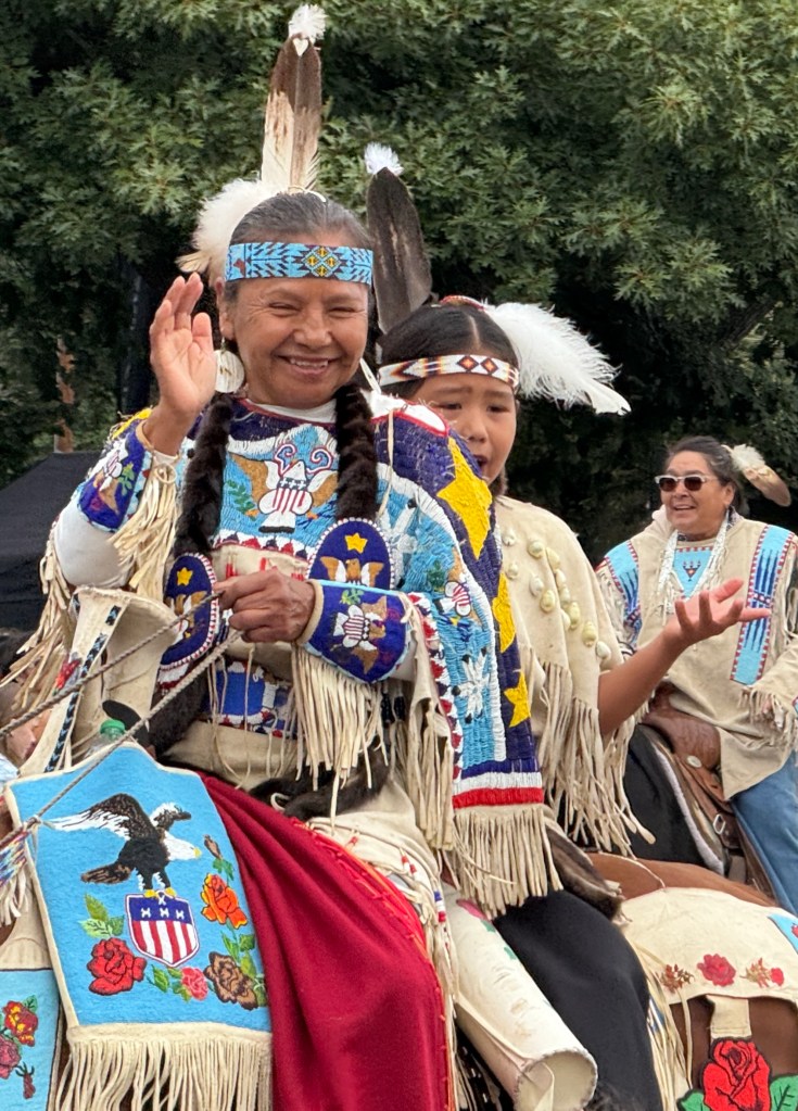 Umatilla Indians in beaded regalia riding a horse