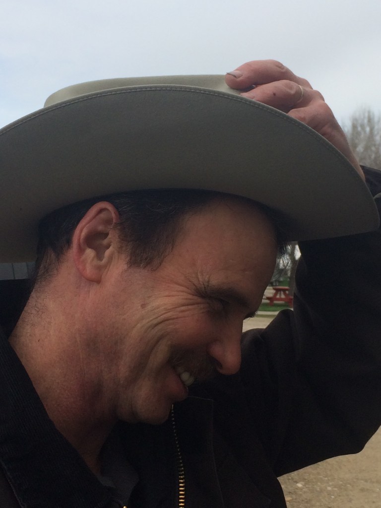author's husband, smiling and tipping a cowboy hat