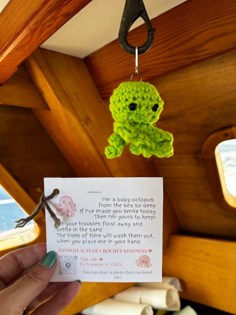 A crocheted octopus hanging in the author's boat, with the poem-note that was found with it. 