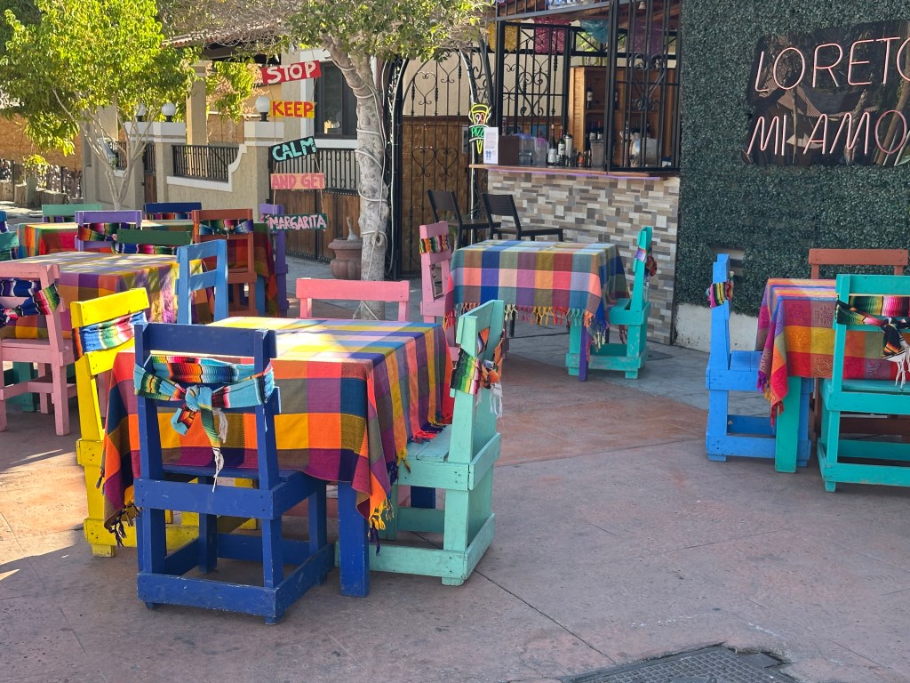 colorful tables and chairs at an outdoor Mexican cafe
